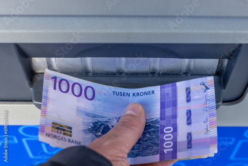 Norway money, 1000 Norwegian kroner banknote withdrawn from an ATM or inserted into a cash deposit machine, Financial concept, Home budget and cash payments photo