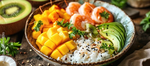 Exotic Hawaiian dish: Shrimp, avocado, rice, mango, kiwi, coconut  beach lunch, tropical food.
