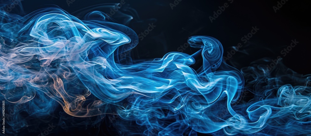 Fototapeta premium Blue smoke trail against black backdrop