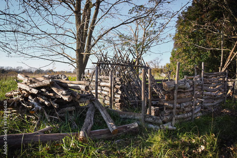 Bushcraft shelter of wood made with logs and sticks with a bed. Bushcraft shelter of wood made with logs and sticks with a bed.
