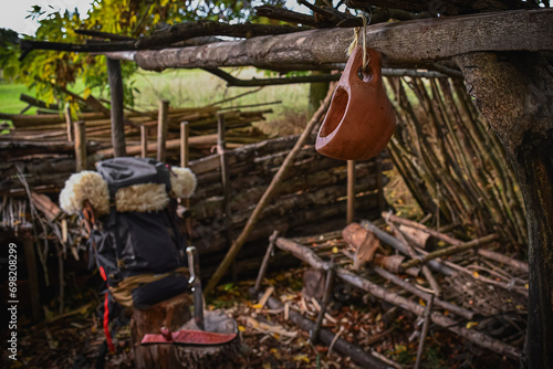 A bushcraft kuksa hand carved with gouges, with a hiking backpack at the background.