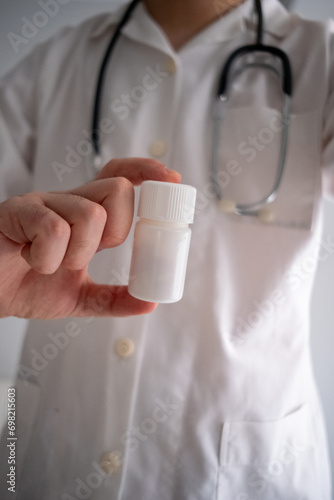 close up of a doctor holding a pill