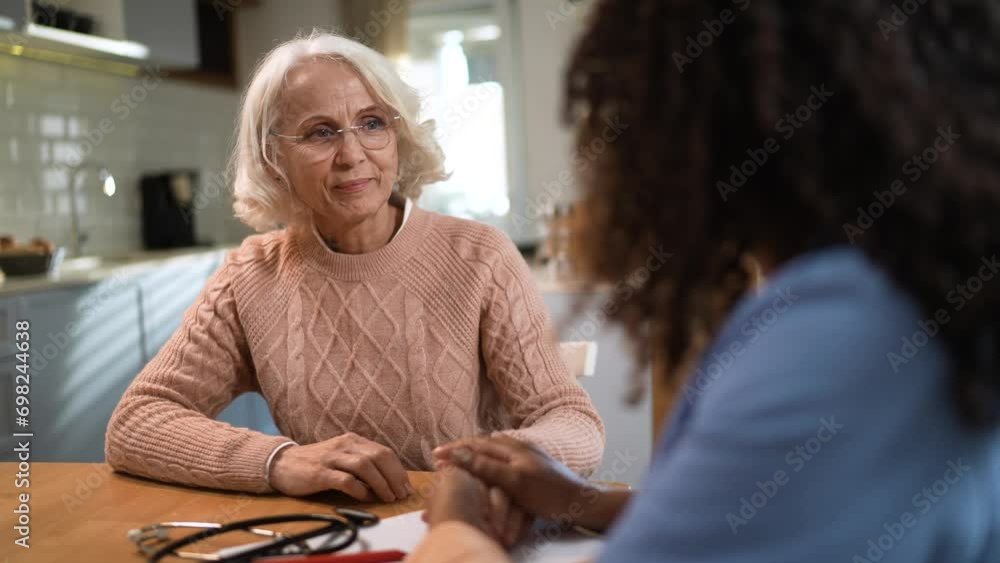 Senior woman talking to caregiver at home Senior woman talking to caregiver at home