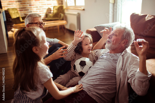 Grandparents and Grandchildren having fun at home photo