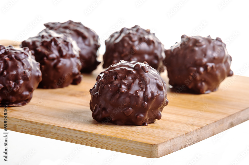 Chocolate balls Delicious pralines on wooden desk isolated on white