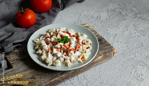 Turkish traditional food ravioli with yoghurt and tomato sauce in plate, manti