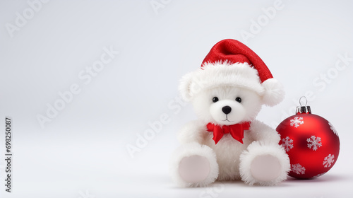  christmas teddy bear. a white teddy bear  with red christmas hat in front of christmas decorations. photo