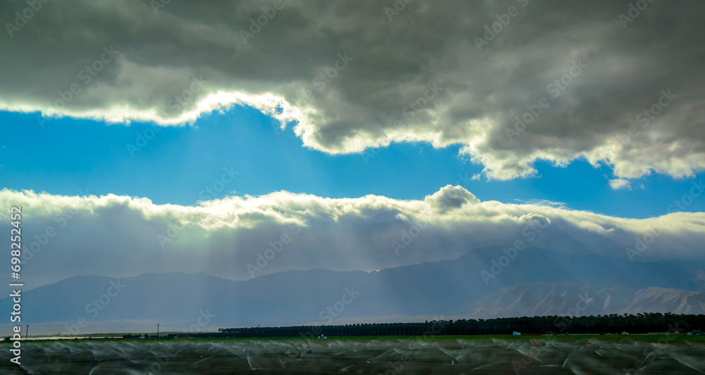 The sun's rays break through the thick clouds over the mountains, State park ANZA-BORREGO DESERT