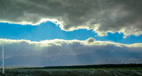 The sun's rays break through the thick clouds over the mountains, State park ANZA-BORREGO DESERT