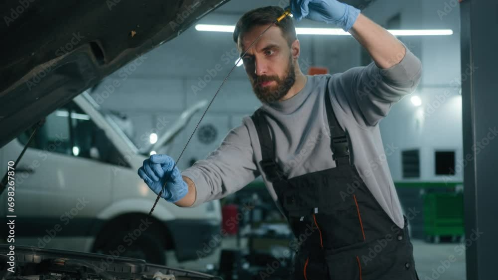 Caucasian 30s man opening car hood in repair workshop check engine oil level at auto service male mechanic maintenance engineer repairing automobile in garage using dipstick tool checking fuel vehicle Caucasian 30s man opening car hood in repair workshop check engine oil level at auto service male mechanic maintenance engineer repairing automobile in garage using dipstick tool checking fuel vehicle