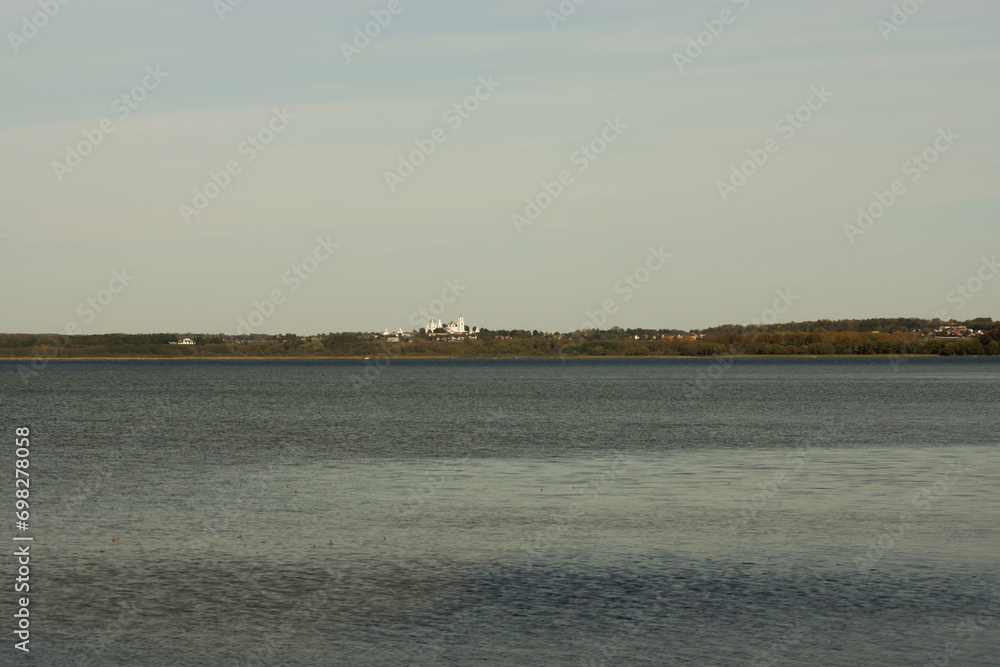 view of Lake Pleshcheyevo with a forested lake shore and St. Nikita's monastery on the horizon