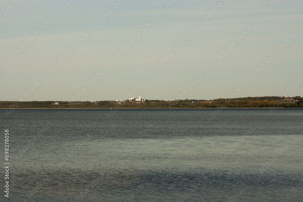 view of Lake Pleshcheyevo with a forested lake shore and St. Nikita's monastery on the horizon view of Lake Pleshcheyevo with a forested lake shore and St. Nikita's monastery on the horizon