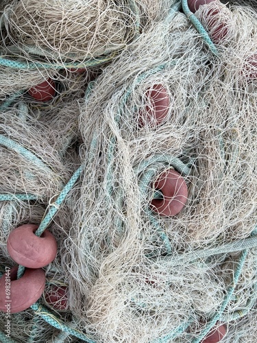 Used Fishing net with buoys, plastic floats  and ropes stored in a bag near boat. Fishing industry waste