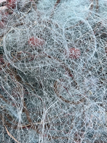 Used Fishing net with buoys, plastic floats  and ropes stored in a bag near boat. Fishing industry waste