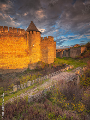 view to walls of fortress in sun light and old bridge