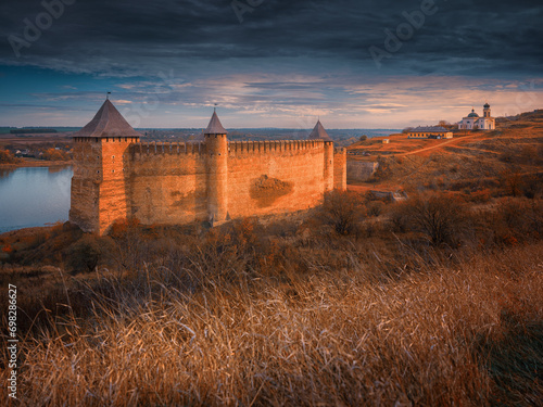 warm sunset light on the walls fortress and hill under dark sky