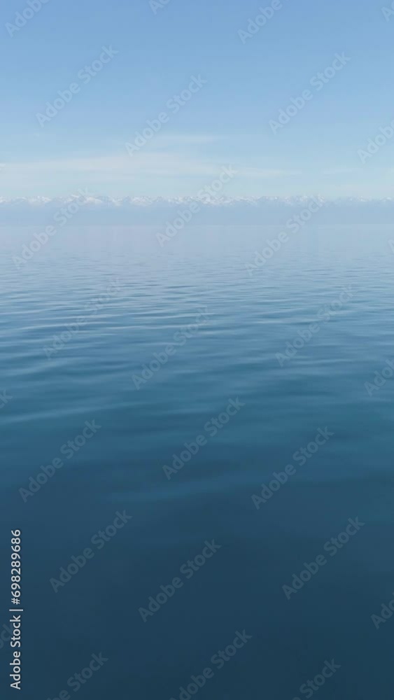 Issyk-Kul lake at Sunny Morning. Kyrgyzstan. Drone is Flying Forward Fast at Low Angle, Camera Tilts Up. Establishing Shot. Vertical Video Issyk-Kul lake at Sunny Morning. Kyrgyzstan. Drone is Flying Forward Fast at Low Angle, Camera Tilts Up. Establishing Shot. Vertical Video