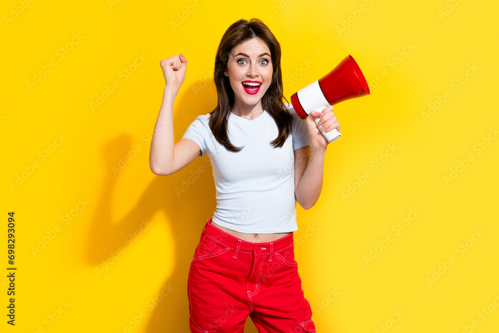 Portrait of overjoyed cheerful girl with retro hairdo wear white t-shirt hold megaphone support you isolated on yellow color background Portrait of overjoyed cheerful girl with retro hairdo wear white t-shirt hold megaphone support you isolated on yellow color background