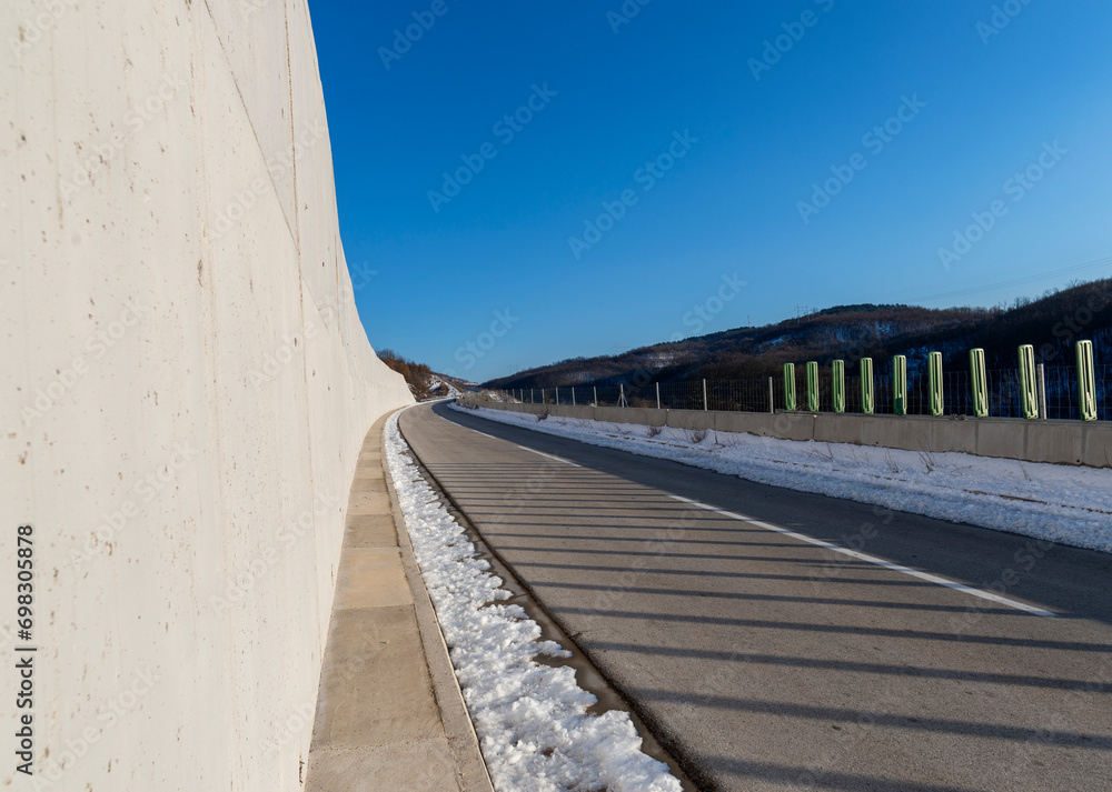 An empty two-lane highway. Winter scene. Empty asphalt road in rural landscape at sunset with blue clouds. Asphalt highway road with beautiful blue sky in pastoral rural environment. An empty two-lane highway. Winter scene. Empty asphalt road in rural landscape at sunset with blue clouds. Asphalt highway road with beautiful blue sky in pastoral rural environment.