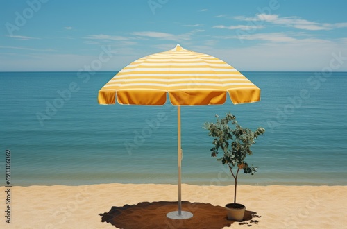Under the warm sun, a vibrant yellow umbrella casts a comforting shade over a small tree on the serene sandy beach, as fluffy clouds drift lazily across the bright blue sky and gentle waves kiss the  photo