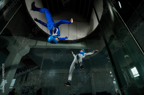 A man and a woman enjoy flying together in a wind tunnel. Free fall simulator