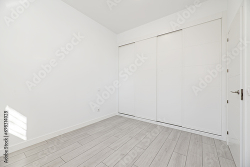 An empty room with built-in wardrobes with white sliding doors