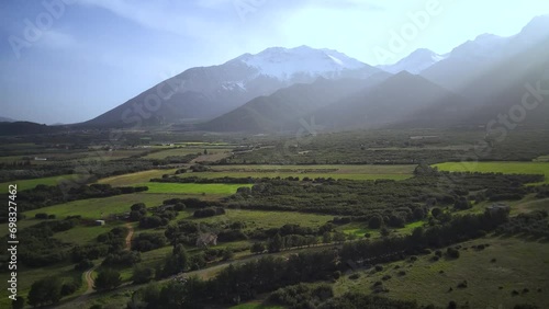 Drone footage of the green fields with mountains under blue dusk sky in the background, Greece photo