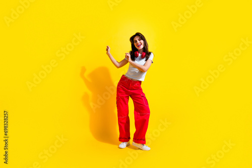 Full length photo of cute pretty woman dressed white t-shirt headphones having fun discotheque empty space isolated yellow color background