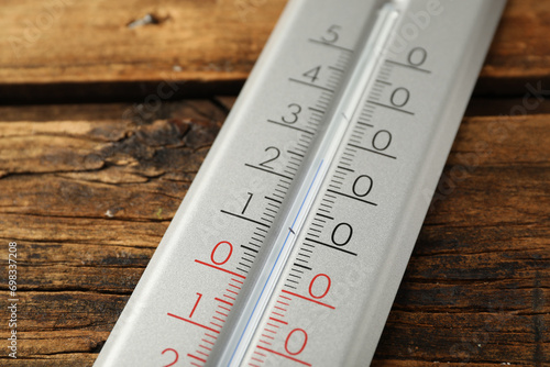 Modern weather thermometer on wooden background, closeup photo