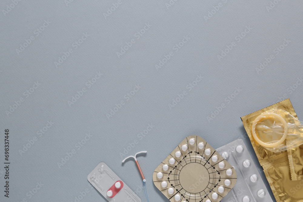 Contraceptive pills, condoms and intrauterine device on gray background, flat lay with space for text. Different birth control methods Contraceptive pills, condoms and intrauterine device on gray background, flat lay with space for text. Different birth control methods