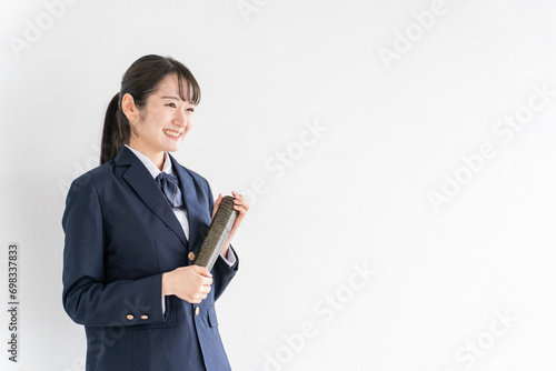 学校の教室で卒業証書を持つ笑顔の高校生・中学生・女子高生（卒業式・制服・学生服） 