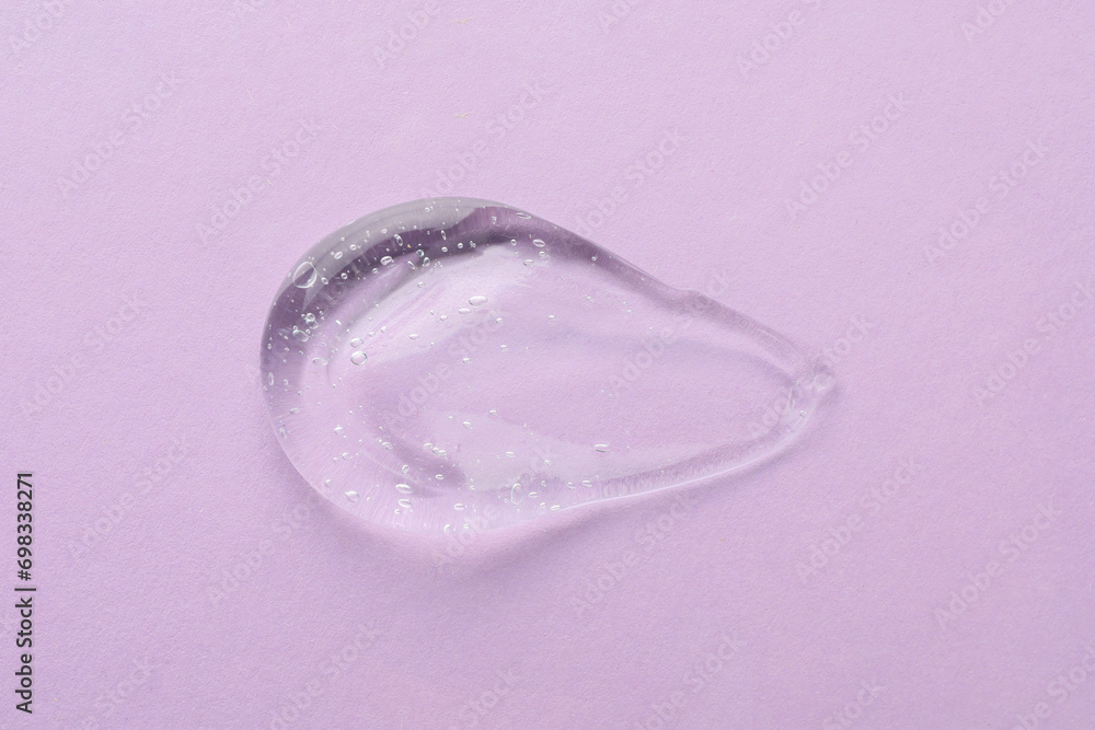 Clear cosmetic gel on light violet background, top view Clear cosmetic gel on light violet background, top view
