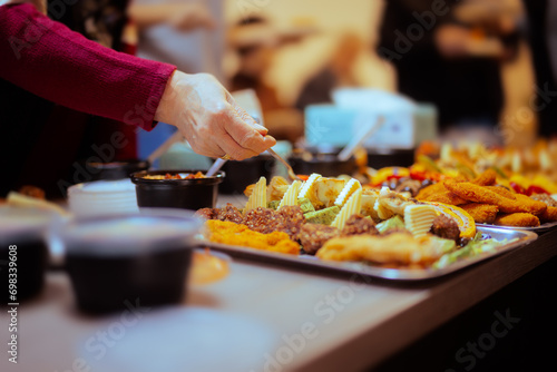 Hands Taking Food from a Table at a Swedish Buffet Party. People enjoying different snacks at a festive gathering 