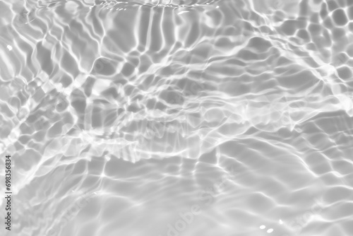 White water with ripples on the surface. Defocus blurred transparent white colored clear calm water surface texture with splashes and bubbles. Water waves with shining pattern texture background.