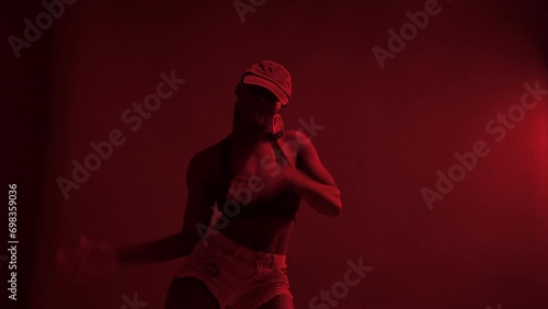 Black woman performing choreography under red lights