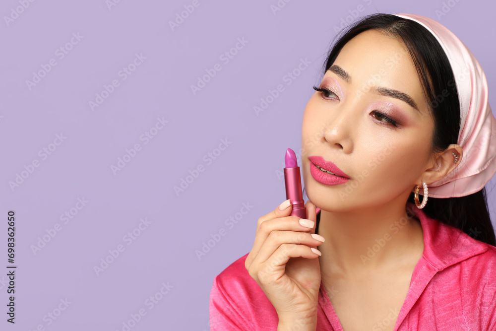Beautiful Asian woman with lipstick on lilac background Beautiful Asian woman with lipstick on lilac background