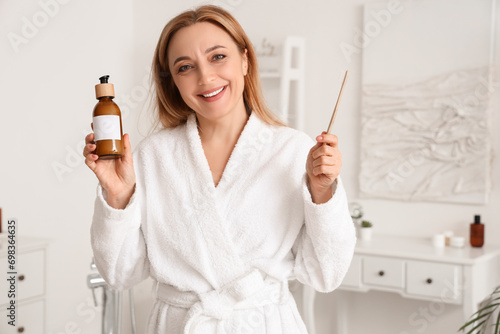 Mature woman with bottle of...