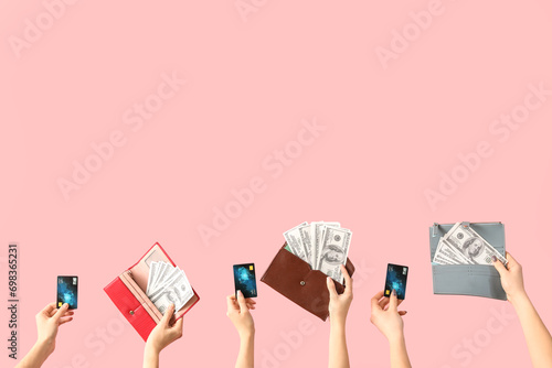 Women with credit cards and dollar banknotes in wallets on pink background