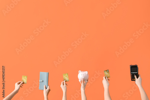 Women with credit cards, wallet, piggy bank and payment terminal on orange background