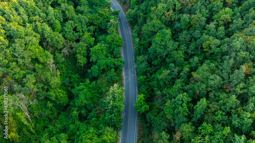 Aerial view of road dark green forest Natural landscape and elevated traffic roads Adventure travel and transportation ideas for the environment photo