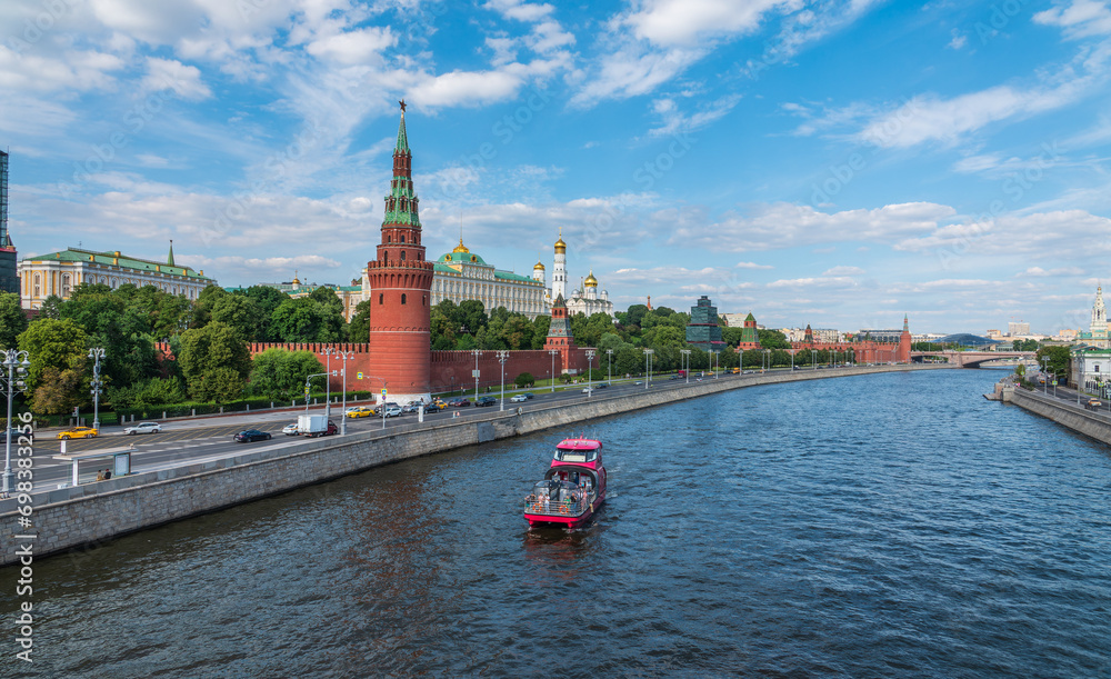 View of Kremlin with Vodovzvodnaya tower, Grand Kremlin Palace from repaired Bolshoy Kamenny Bridge in Moscow city on sunny summer day. Cruise ship sails on the Moscow river View of Kremlin with Vodovzvodnaya tower, Grand Kremlin Palace from repaired Bolshoy Kamenny Bridge in Moscow city on sunny summer day. Cruise ship sails on the Moscow river