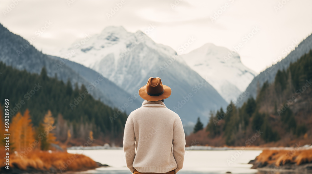 man in orange hat looking at the mountain range