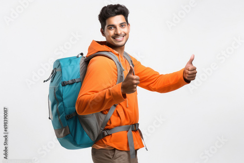 Young indian boy showing thumps up with backpack on white background.