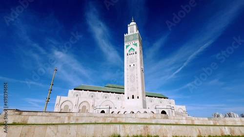Casablanca. Serene Dawn at Hassan II Mosque: Experience the tranquil beauty of dawn at the iconic Hassan II Mosque. This clip captures the first sun rays lighting up its minarets and water reflections photo
