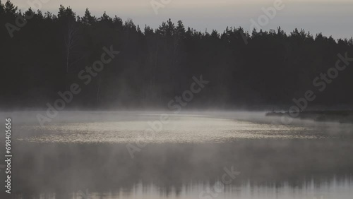 Mist, fog rises from the swamp lake, early in the morning. Cool color mood. photo
