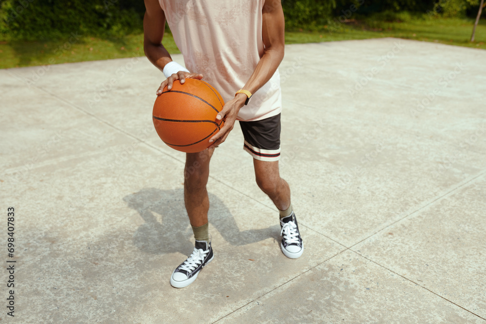 Cropped image of sweaty sportsman playing streetball on court Cropped image of sweaty sportsman playing streetball on court