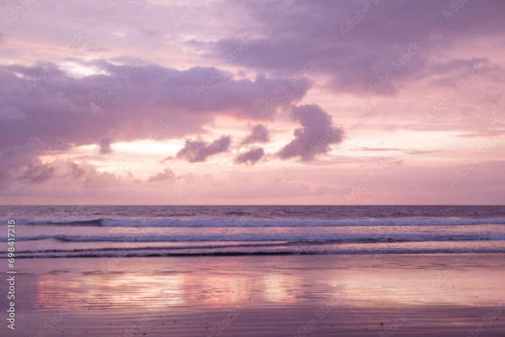 Beautiful peach sunset over the ocean and purple clouds.