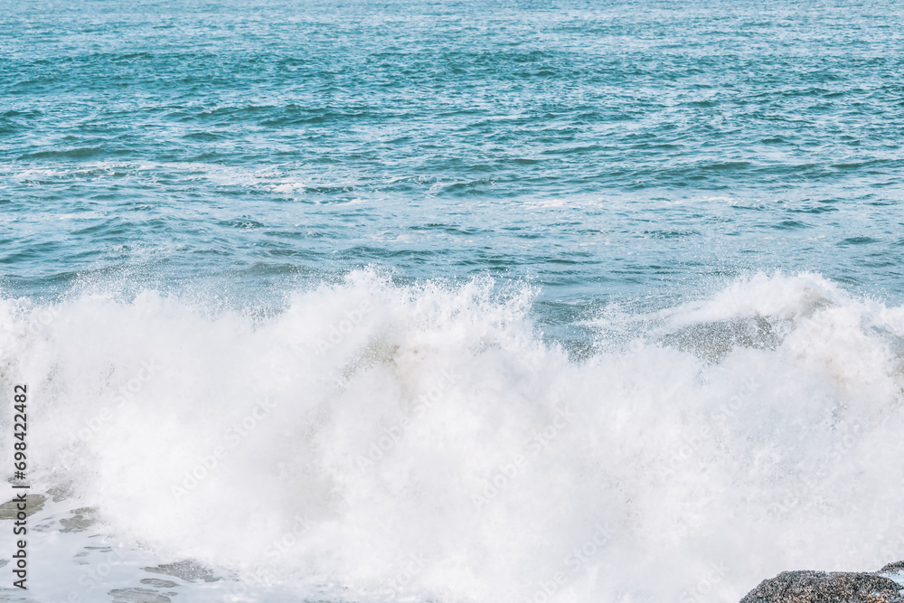 Wave splashes close-up. Crystal clear sea water hitting rock formations in the ocean in San Francisco Bay, blue water, pastel colors. Wave splashes close-up. Crystal clear sea water hitting rock formations in the ocean in San Francisco Bay, blue water, pastel colors.