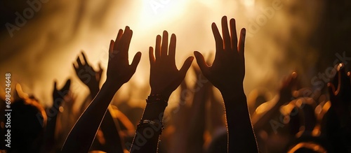 Christian hands lifted in worship, forming a silhouette.