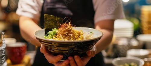 Foto A noodle bowl offered by a ramen shop worker.